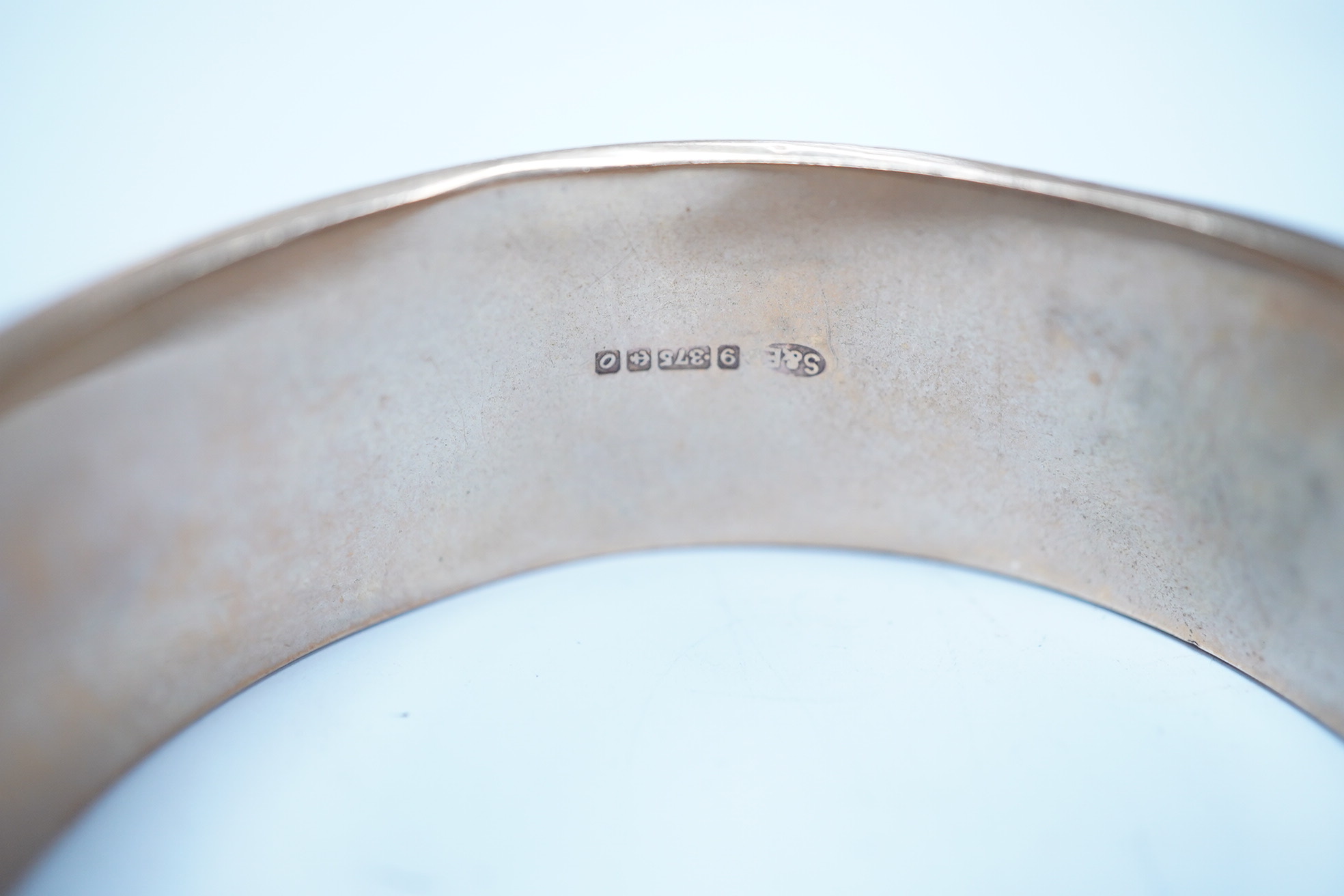 A 1960's engraved 9ct gold hinged bangle, 24.1 grams. Condition - poor